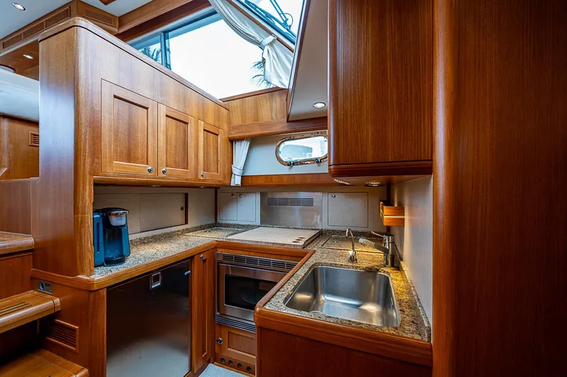 Slide: The Image of Luxurious 2014 Grand Banks 46 Eastbay SX yacht kitchen with wood cabinetry and modern appliances. - 27
