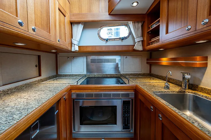 Slide: The Image of Luxurious 2014 Grand Banks 46 Eastbay SX yacht kitchen with wood cabinetry and granite countertops. - 28