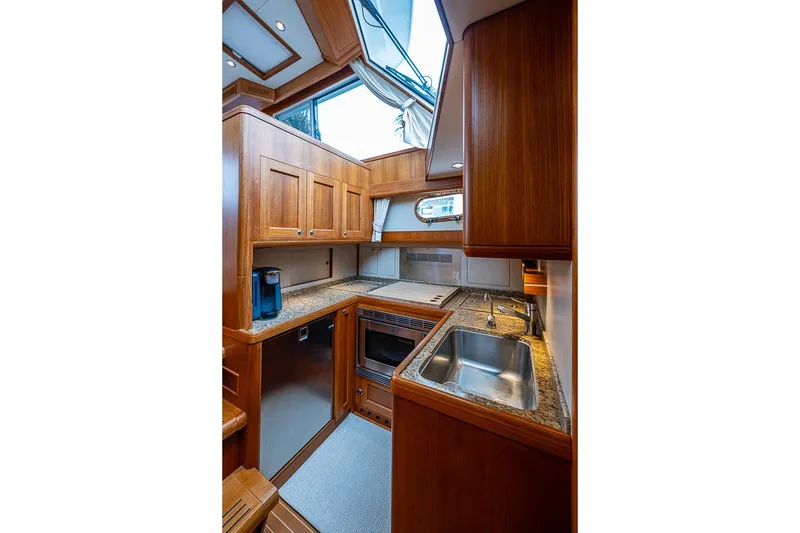 Slide: The Image of Luxurious 2014 Grand Banks 46 Eastbay SX yacht kitchen with wood cabinetry and modern appliances. - 30