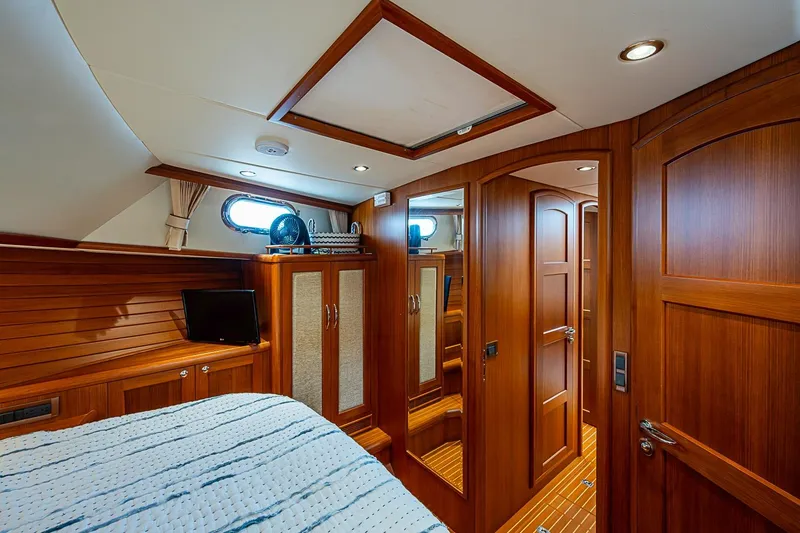 Slide: The Image of Luxurious 2014 Grand Banks 46 Eastbay SX yacht cabin with wood paneling and cozy bedding. - 33