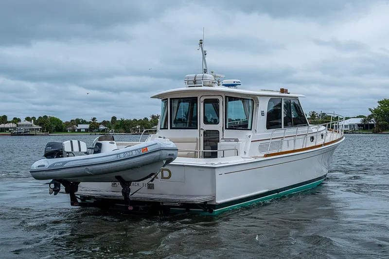 Slide: The Image of 2014 Grand Banks 46 Eastbay SX yacht on water with inflatable boat attached. - 6