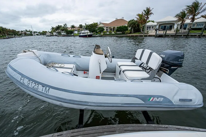Slide: The Image of Inflatable boat with Yamaha motor docked on a waterfront, near luxury homes. - 7