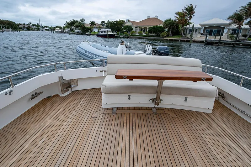 Slide: The Image of 2014 Grand Banks 46 Eastbay SX yacht deck with seating and table, docked by waterfront homes. - 8