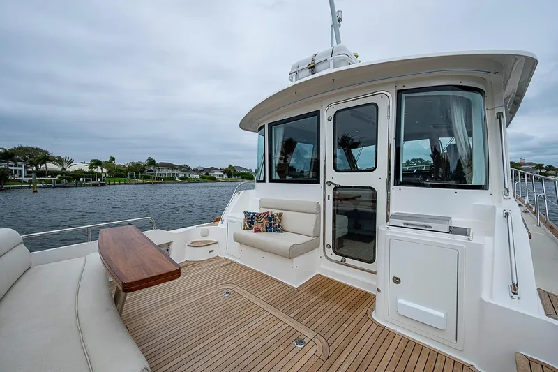 Slide: The Image of 2014 Grand Banks 46 Eastbay SX yacht deck with seating and scenic waterfront view. - 9