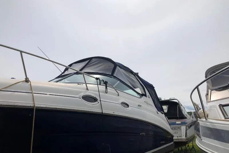 Slide: The Image of 2005 Sea Ray Sundancer 280 boat docked alongside other vessels under a cloudy sky. - 10