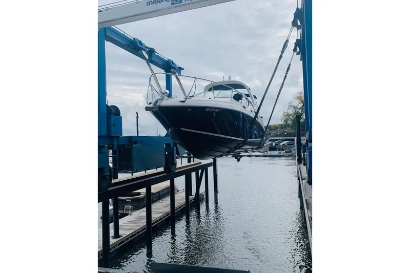 Slide: The Image of 2005 Sea Ray Sundancer 280 being lifted by a boat hoist at a marina. - 11