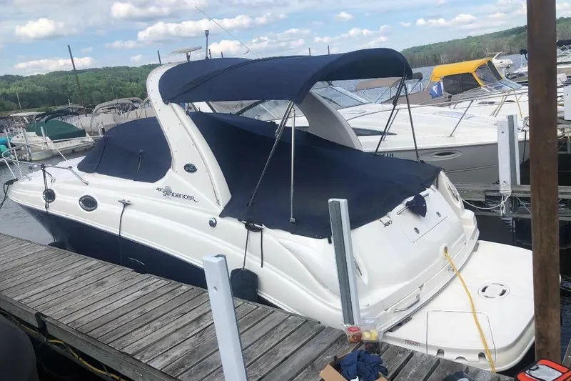 Slide: The Image of 2005 Sea Ray Sundancer 280 docked at a marina with a blue canopy. - 3