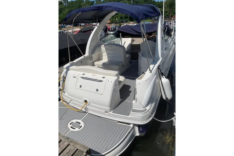 Slide: The Image of 2005 Sea Ray Sundancer 280 boat docked, featuring spacious seating and a blue canopy. - 5