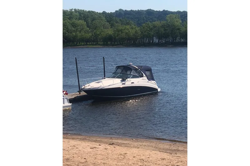 Slide: The Image of 2005 Sea Ray Sundancer 280 docked on a calm lake with lush green trees. - 9