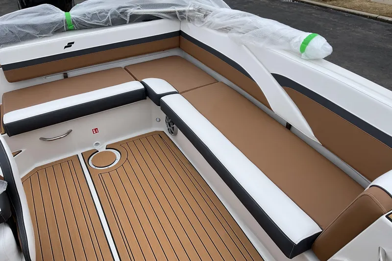 Slide: The Image of 2026 Starcraft SVX 211 OB boat interior with tan and white seating, wood-style flooring. - 14