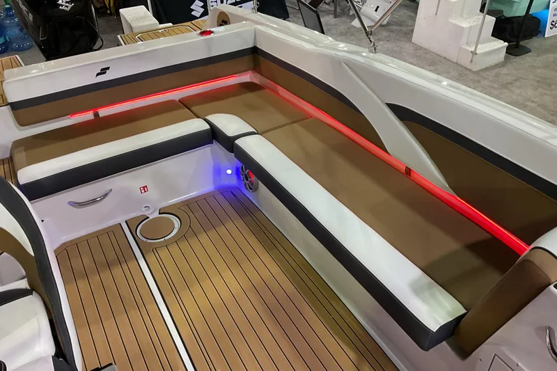 Slide: The Image of 2026 Starcraft SVX 211 OB boat interior with brown seating, red LED lighting, and wood-style flooring. - 5