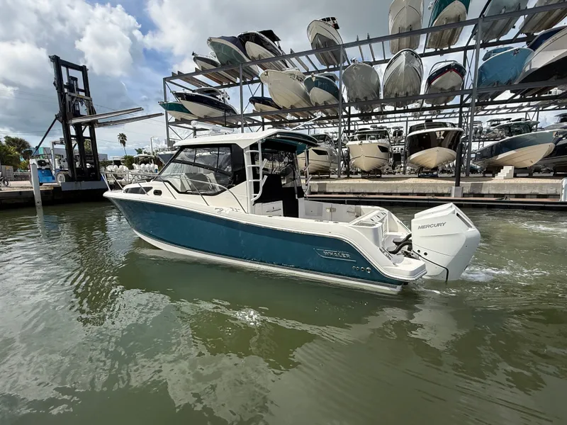 Slide: The Image of A 2027 Boston Whaler 325 Conquest in the water, surrounded by stacked boats in the background. - 7