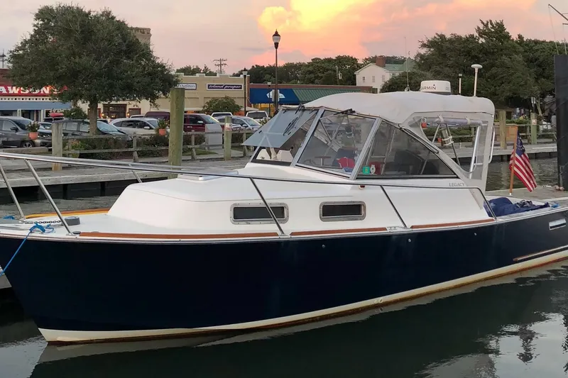 The Image of 2003 Legacy Yachts 28 docked at sunset, featuring sleek design and American flag. - 0