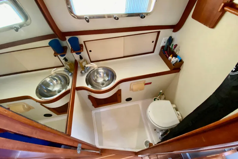 Slide: The Image of Interior of 2003 Legacy Yachts 28, featuring cozy cabin, wooden finishes, and compact bathroom. - 14