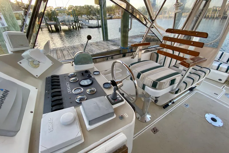 Slide: The Image of 2003 Legacy Yachts 28 interior with striped seating, overlooking a serene waterfront view. - 16