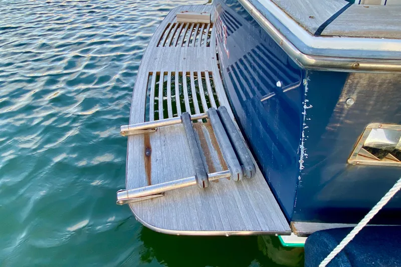 Slide: The Image of 2003 Legacy Yachts 28 with striped seating, docked on calm water. - 18