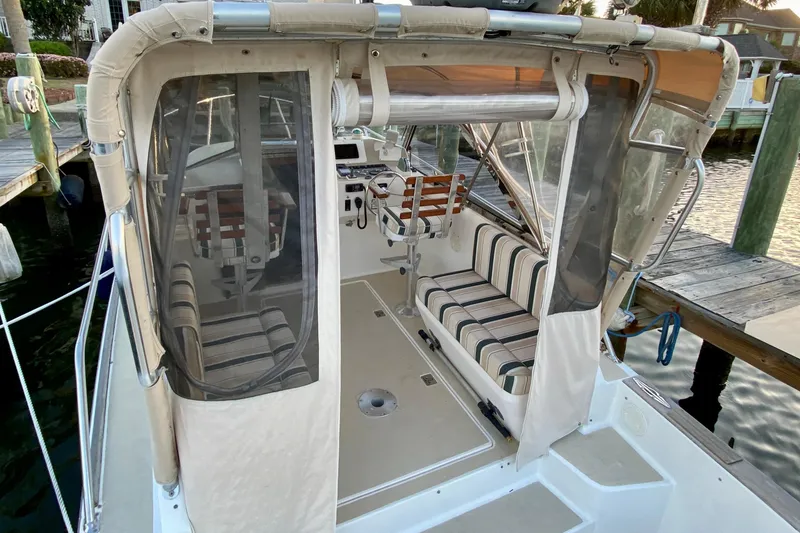 Slide: The Image of 2003 Legacy Yachts 28 deck view with hatch, docked by wooden pier. - 25