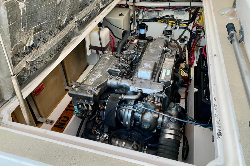 Slide: The Image of 2003 Legacy Yachts 28 with striped seating, docked at a marina. - 26