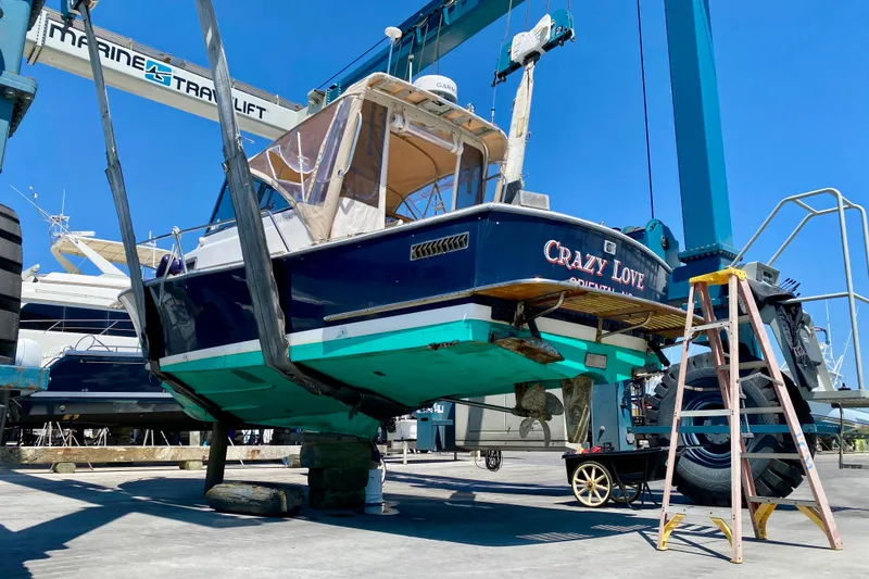 Slide: The Image of 2003 Legacy Yachts 28 on lift for maintenance at marina. - 32
