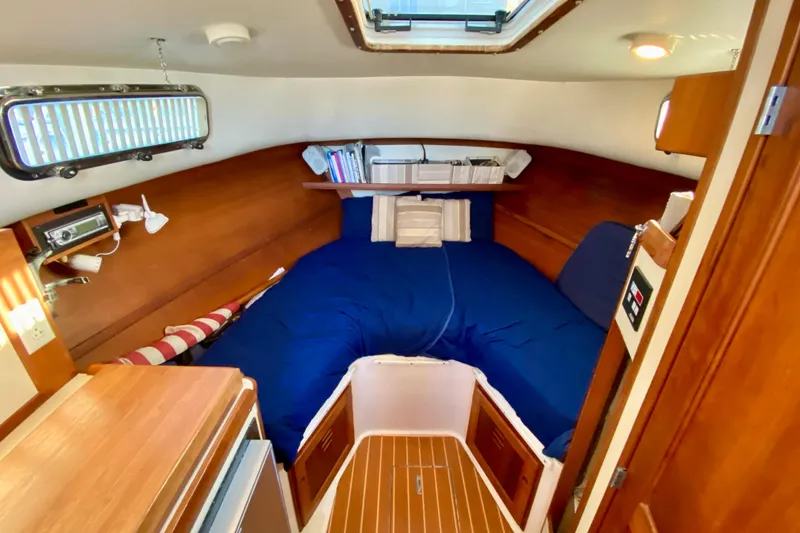 Slide: The Image of Interior of 2003 Legacy Yachts 28, featuring kitchenette and cozy cabin space. - 7