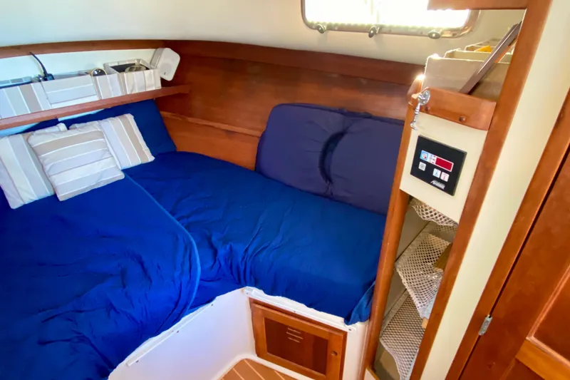 Slide: The Image of Cozy cabin interior of 2003 Legacy Yachts 28 with blue bedding and wooden accents. - 8