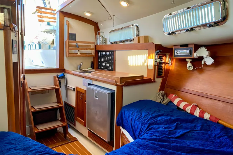 Slide: The Image of Cozy cabin interior of 2003 Legacy Yachts 28 with blue bedding and wooden accents. - 9