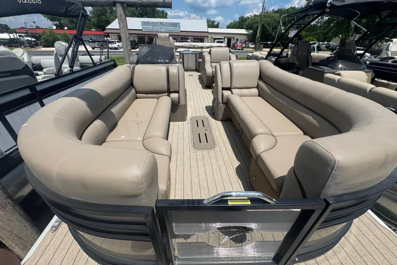Slide: The Image of 2023 Veranda VTX 25RFL pontoon boat with spacious beige seating and modern design. - 2