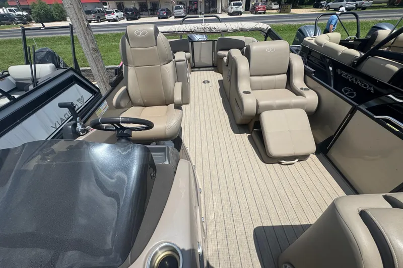 Slide: The Image of 2023 Veranda VTX 25RFL pontoon boat interior with beige seating and steering console. - 4