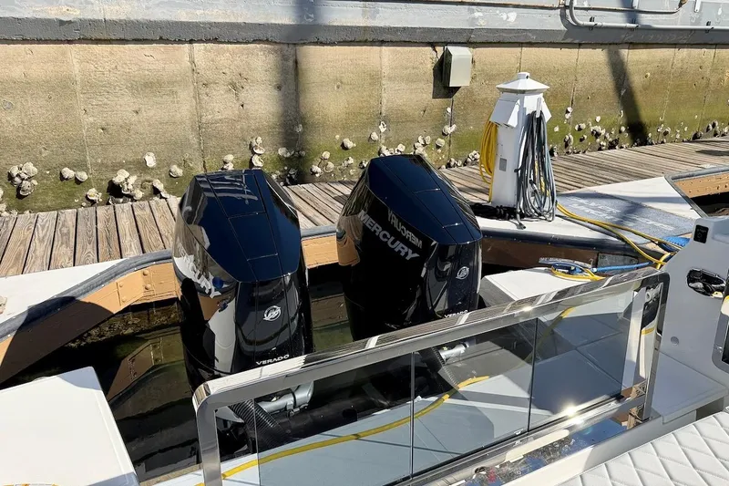 Slide: The Image of Twin Mercury Verado engines on a 2026 Saxdor 400 GTC boat docked at a marina. - 10