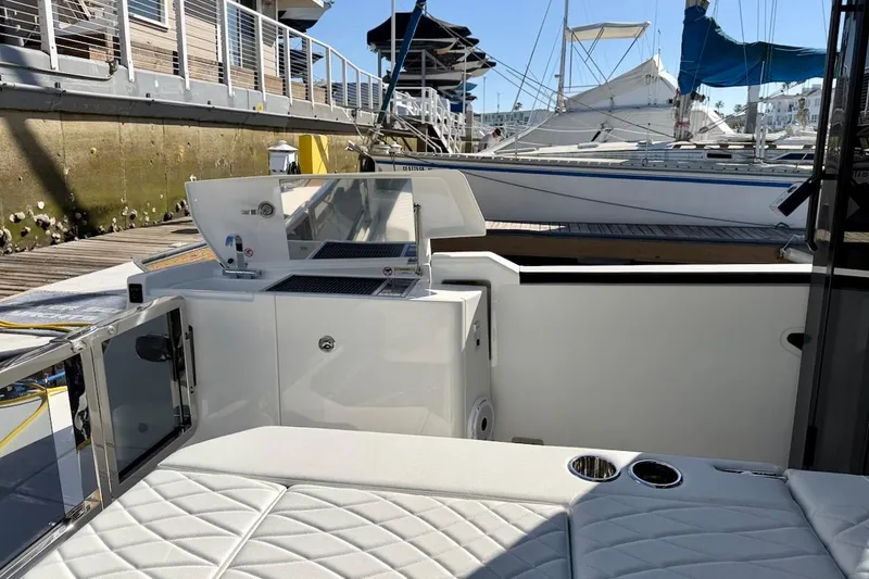 Slide: The Image of Modern Saxdor 400 GTC yacht interior, featuring sleek seating and a compact kitchenette, docked at a marina. - 12
