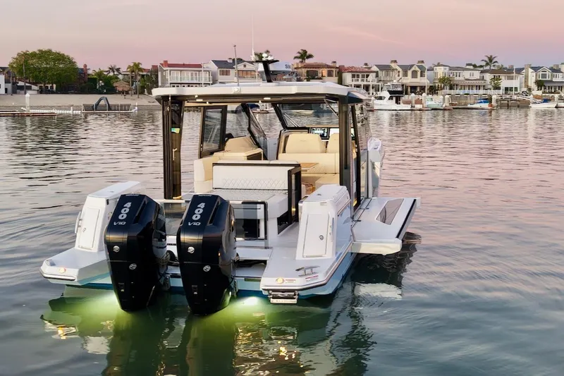 Slide: The Image of 2026 Saxdor 400 GTC boat with dual engines, docked at sunset near waterfront homes. - 9