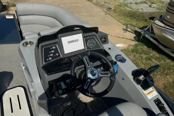 Slide: The Image of 2024 Veranda VTX 22VLB boat dashboard with steering wheel and Simrad display. - 6