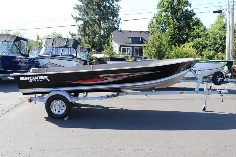 The Image of 2025 Smoker Craft Voyager 16 boat on trailer, parked outdoors. - 1