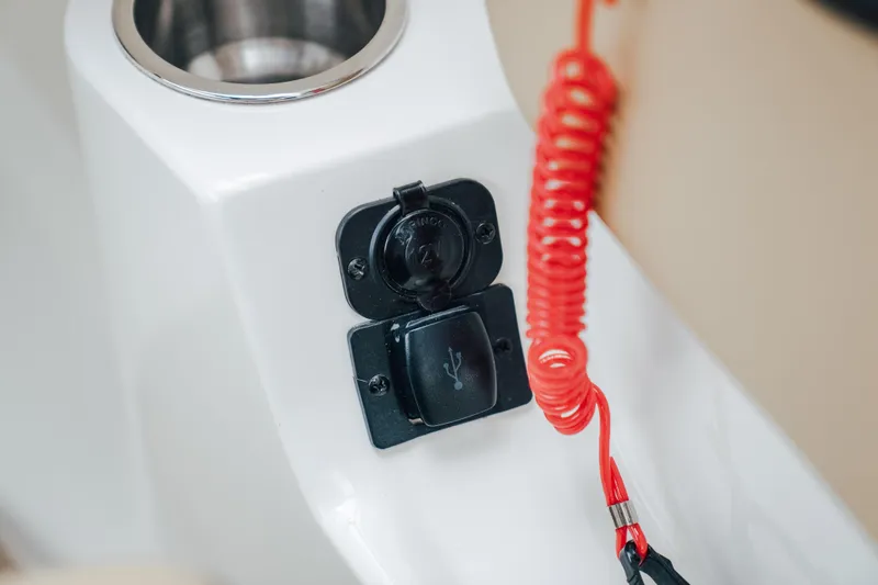 Slide: The Image of USB port and cup holder on 2024 Sea Ray SPX 230 boat console. - 11