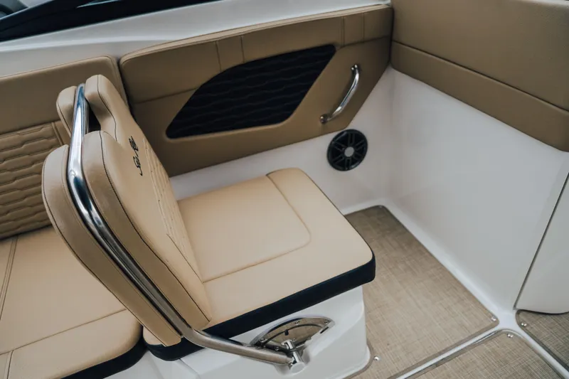 Slide: The Image of 2024 Sea Ray SPX 230 boat interior with tan seating and stainless steel accents. - 16