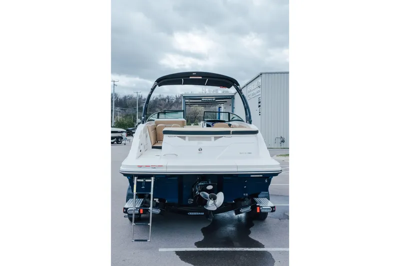 Slide: The Image of 2024 Sea Ray SPX 230 boat, rear view, parked outdoors under cloudy sky. - 3