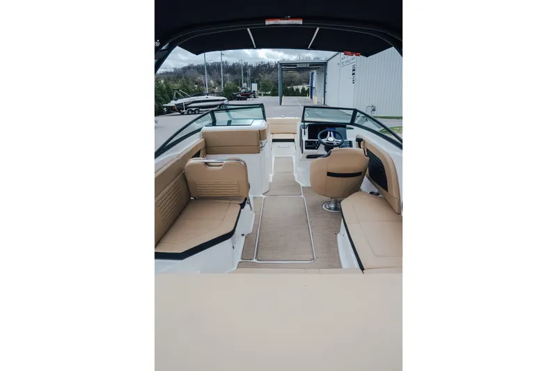 Slide: The Image of 2024 Sea Ray SPX 230 boat interior with tan seating and modern dashboard. - 5