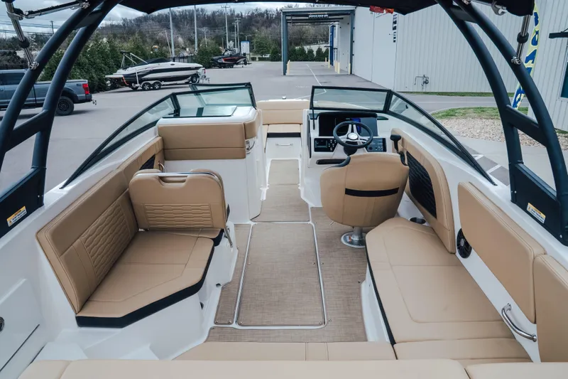 Slide: The Image of 2024 Sea Ray SPX 230 boat interior with tan seating and modern dashboard. - 6