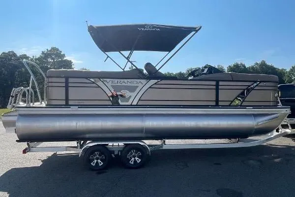 Slide: The Image of 2024 Veranda VTX 22RC pontoon boat on trailer, featuring a sleek design and canopy. - 2
