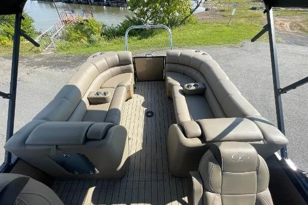 Slide: The Image of 2024 Veranda VTX 22RC pontoon boat with spacious seating and cup holders, docked near water. - 5