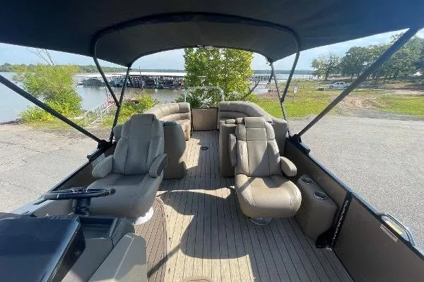 Slide: The Image of 2024 Veranda VTX 22RC pontoon boat with spacious seating and canopy, docked by a scenic lake. - 7