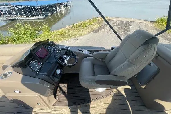 Slide: The Image of 2024 Veranda VTX 22RC boat interior with steering wheel and captain's chair by the water. - 9