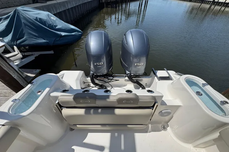 Slide: The Image of 2022 Key West 244 Center Console boat with twin Yamaha 150 engines docked by water. - 12