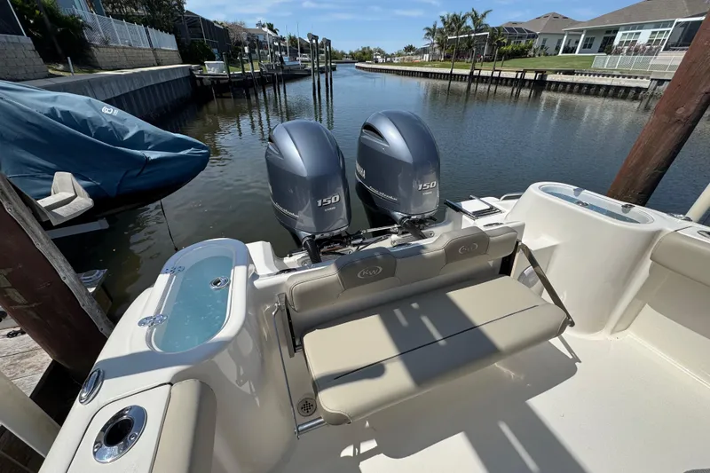 Slide: The Image of 2022 Key West 244 Center Console boat with dual Yamaha 150 engines docked in a canal. - 13