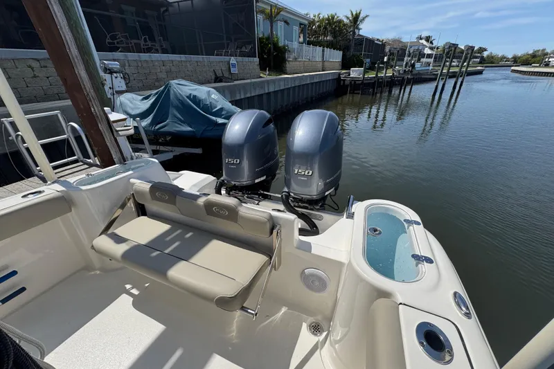 Slide: The Image of 2022 Key West 244 Center Console boat with twin 150 engines docked by a canal. - 14