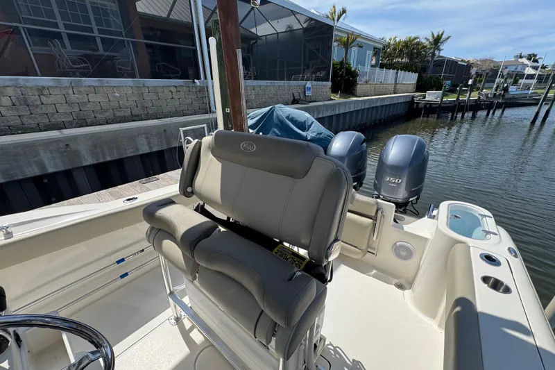 Slide: The Image of 2022 Key West 244 Center Console boat with dual engines docked by waterfront homes. - 23