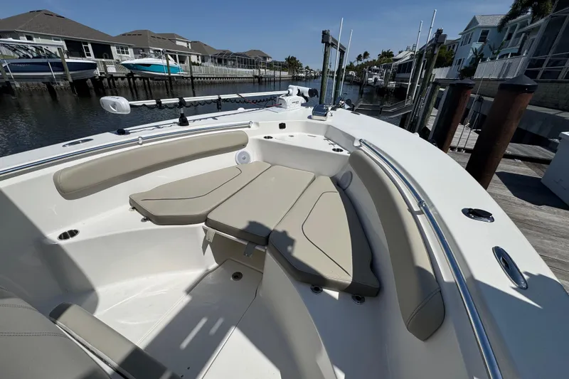 Slide: The Image of 2022 Key West 244 Center Console boat with beige seating in a marina setting. - 35