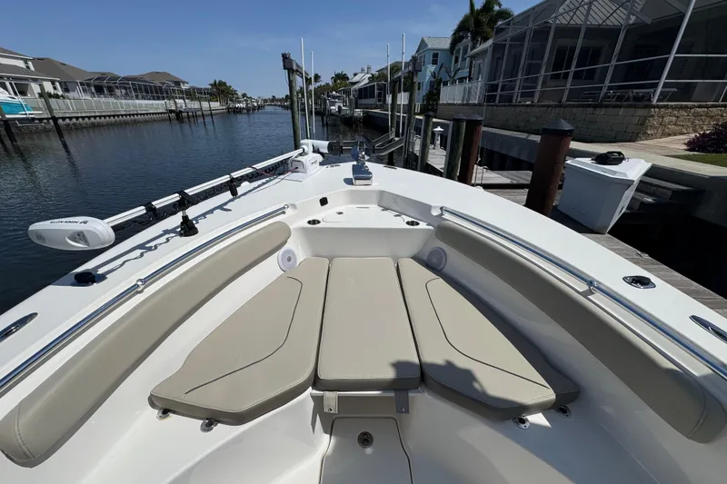 Slide: The Image of 2022 Key West 244 Center Console boat interior with beige seating, docked by waterfront homes. - 36