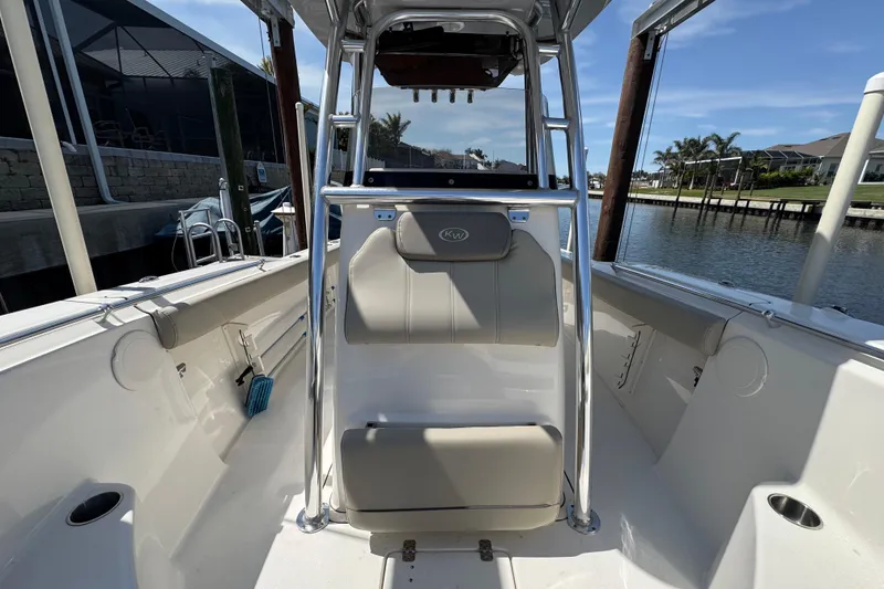 Slide: The Image of 2022 Key West 244 Center Console boat interior with seating and console, docked by waterfront. - 37