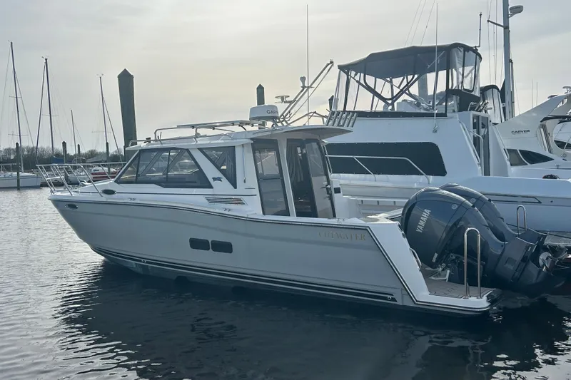 The Image of 2024 Cutwater C-288 Coupe boat docked in marina with Yamaha engines. - 0
